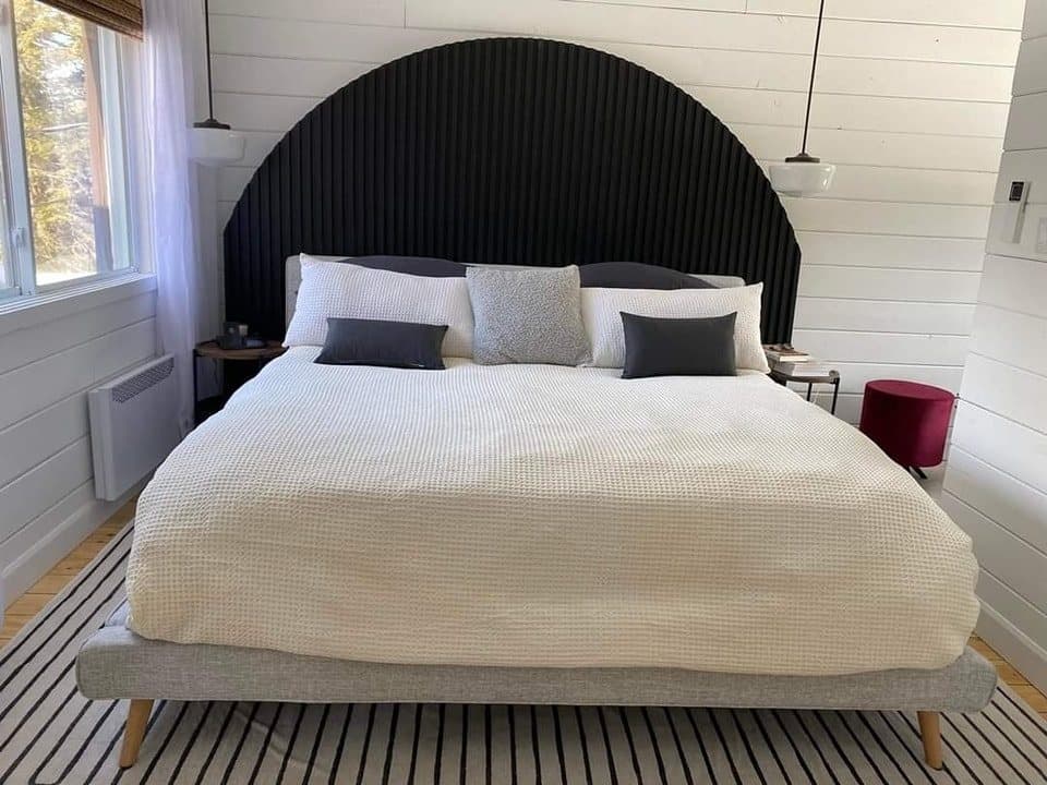 Chambre avec murs de lambris blanc et tête de lit sur mesure
