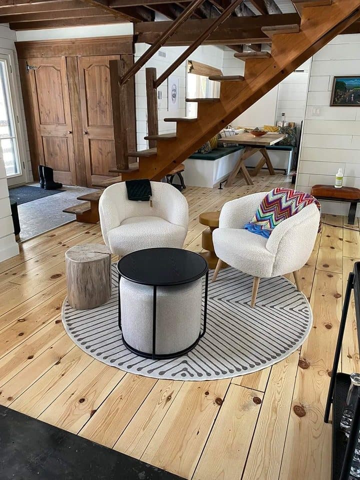 Séjour avec plancher de pin et escalier de bois ouvert