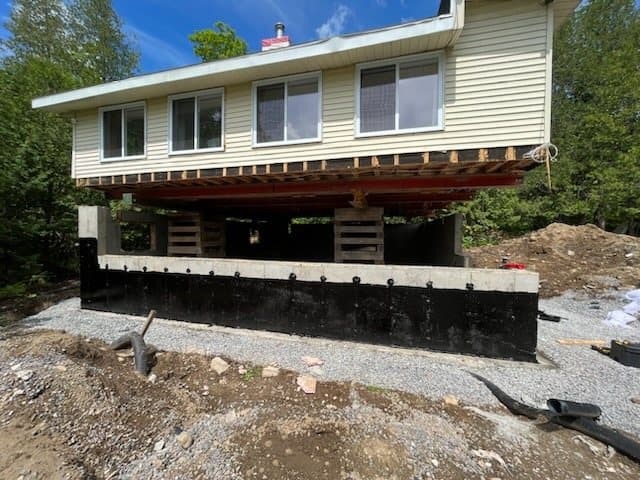 Maison soulevée sur étaiement pendant la construction d'une nouvelle fondation